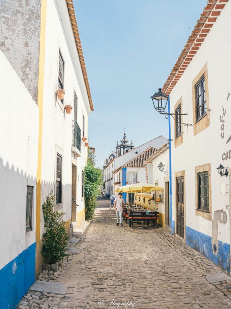 rue d'Obidos au Portugal avec maison jaune et bleu et l'église